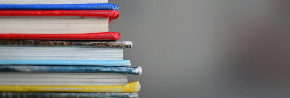 A stack of hardback books in bright colours
